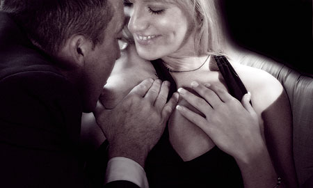 homme l&eacute;chant le sein de sa femme